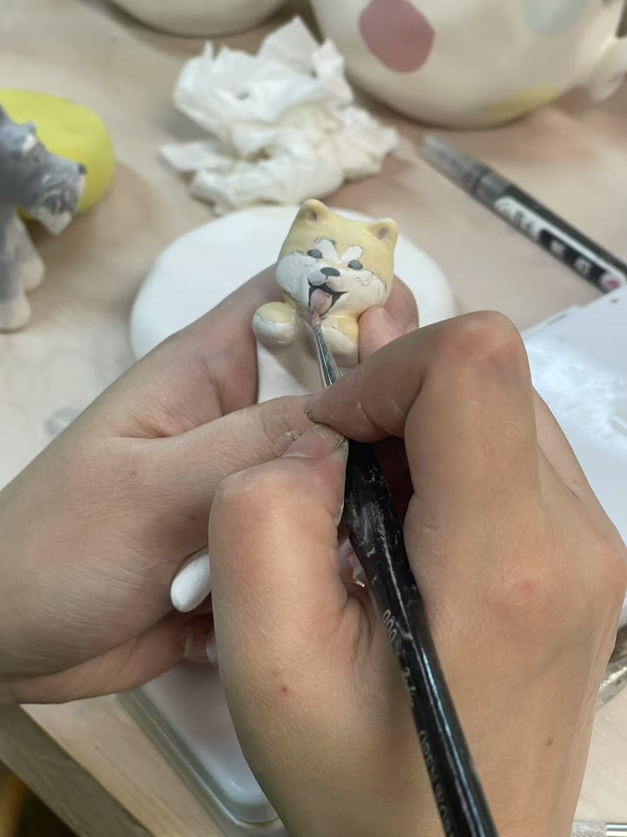Everlou artisan hand-sculpting a pet figure in the studio